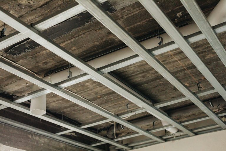 Trockenbaudecke Metallkonstruktion Deckenkonstruktion mit Metallprofilen und Holzpanelen, teilweise sichtbar.